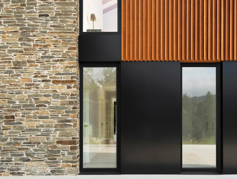 Cortizo PVC Hidden Sash Windows Cortizo PVC hidden sash windows in a modern stone and wood façade