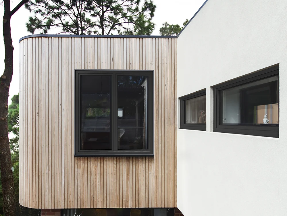 Cortizo PVC Windows – Contemporary Style Black Cortizo PVC windows in a façade with wood cladding